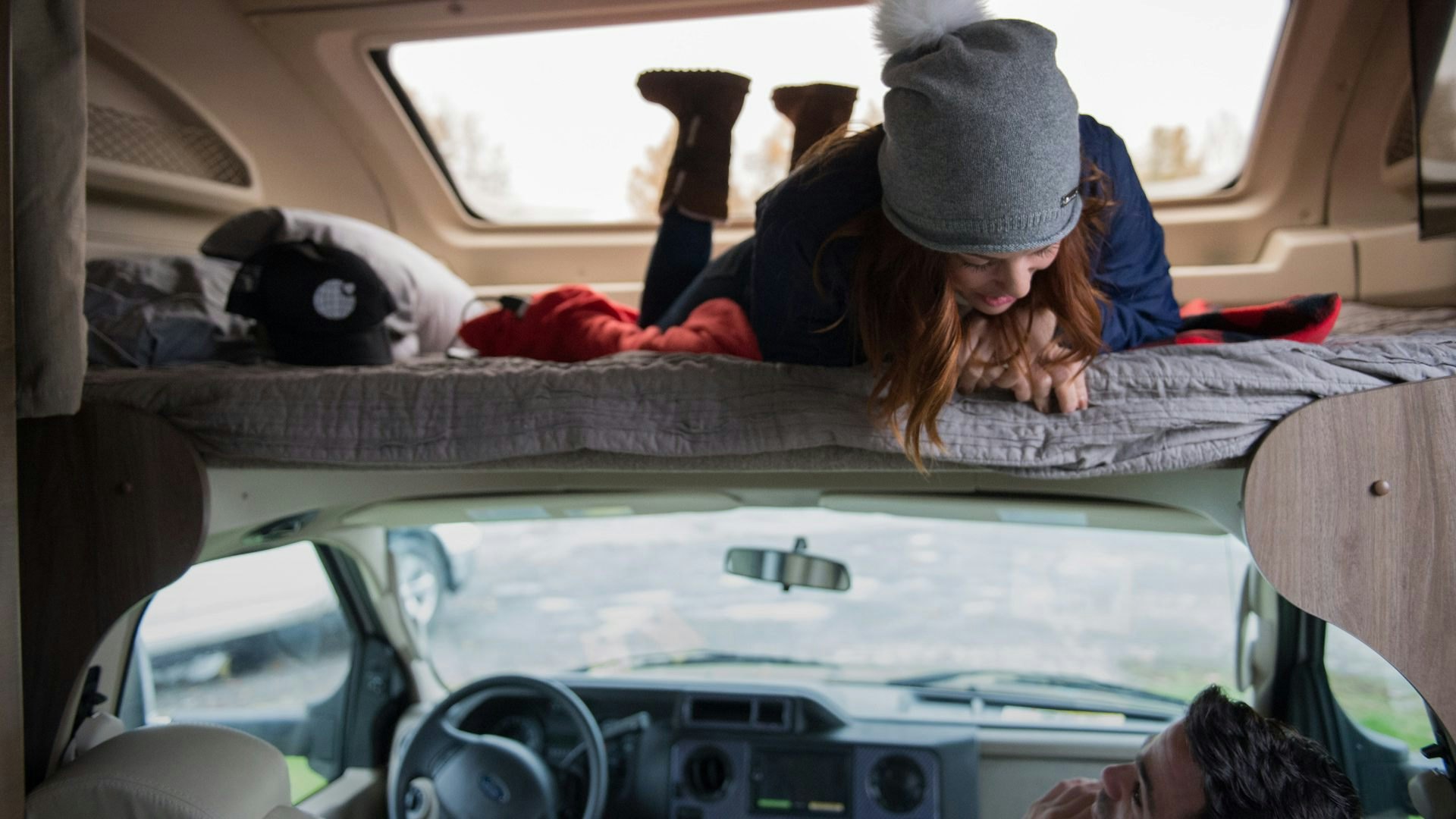 woman in roof top tent talking to man in car